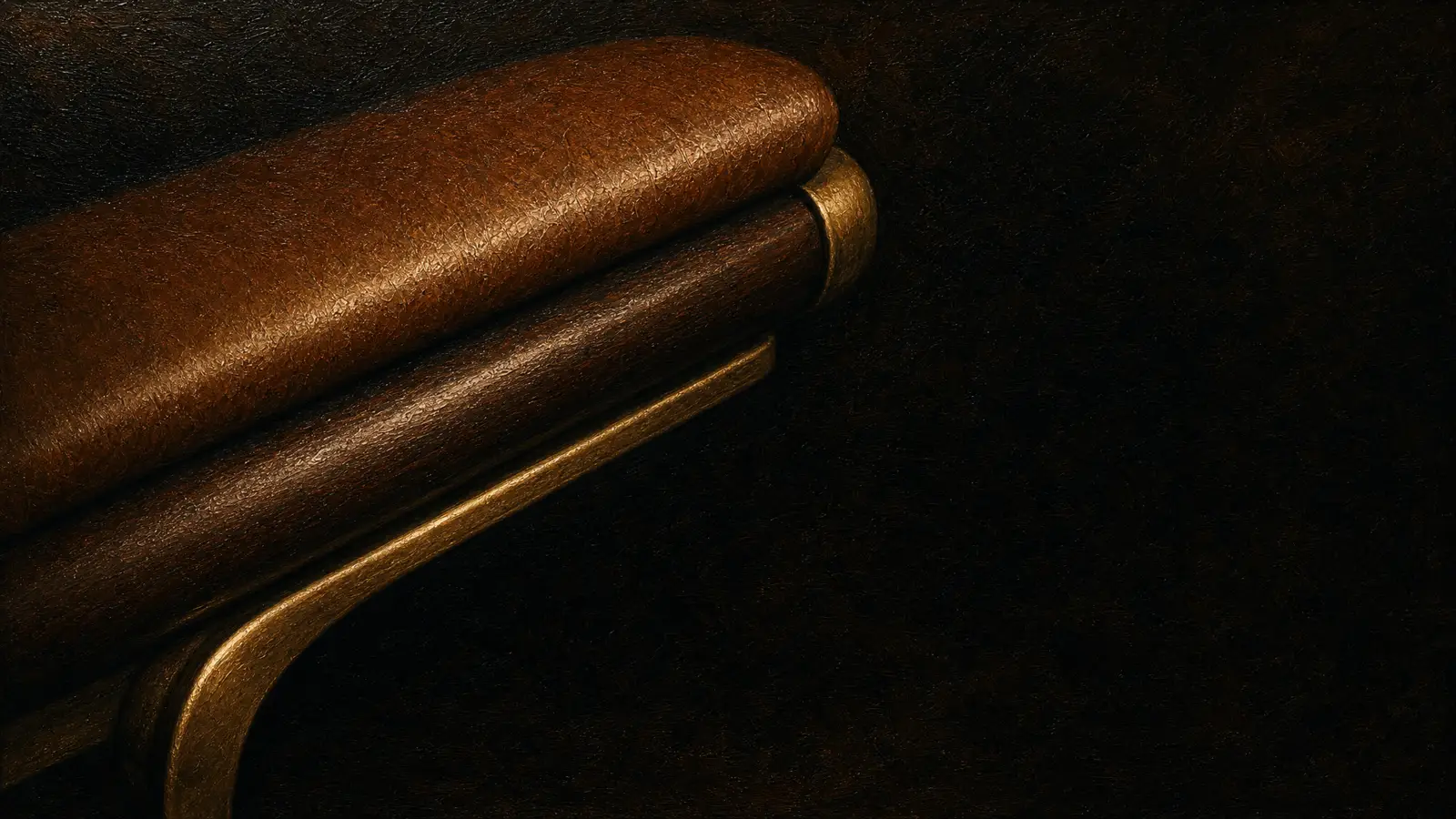 The leather and gold arm of the barber chair